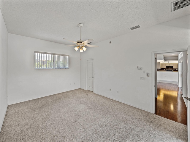 unfurnished room featuring a textured ceiling, ceiling fan, carpet floors, and visible vents