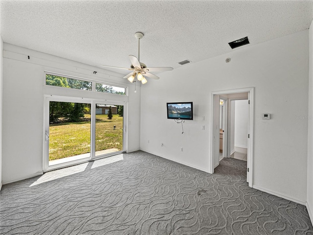 spare room with carpet, ceiling fan, visible vents, and a textured ceiling