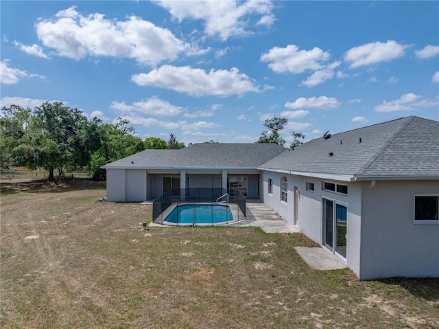 back of house featuring stucco siding, a yard, roof with shingles, a patio area, and an outdoor pool