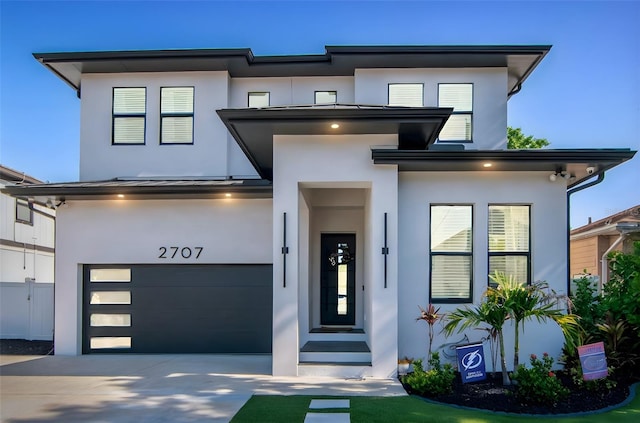 view of front facade with concrete driveway, a garage, and stucco siding