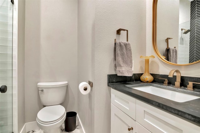 full bath featuring toilet, vanity, and baseboards