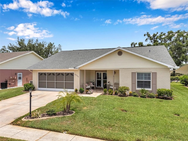 9335 Stonewall, New Port Richey, FL 34655 - view of front of house featuring a garage, a front lawn, driveway, and brick siding