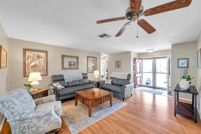 9335 Stonewall, New Port Richey, FL 34655 - living area with light wood finished floors, a textured ceiling, and ceiling fan