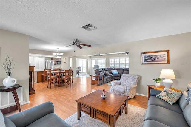 9335 Stonewall, New Port Richey, FL 34655 - living area with ceiling fan, light wood-style floors, a textured ceiling, baseboards, and a chandelier