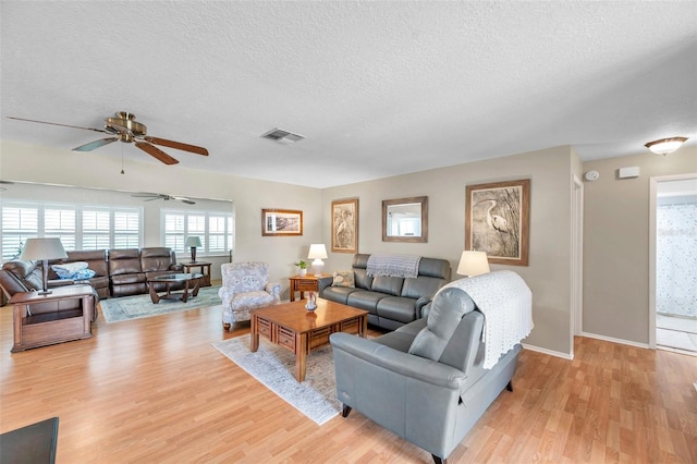 9335 Stonewall, New Port Richey, FL 34655 - living area featuring a textured ceiling, light wood-style floors, ceiling fan, and baseboards