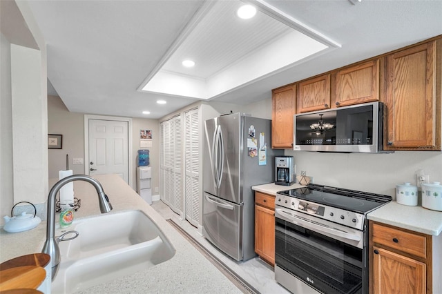 9335 Stonewall, New Port Richey, FL 34655 - kitchen featuring stainless steel appliances, a sink, brown cabinets, light countertops, and recessed lighting