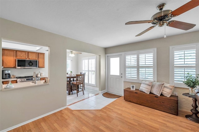 9335 Stonewall, New Port Richey, FL 34655 - living room featuring a ceiling fan, light wood-type flooring, and baseboards