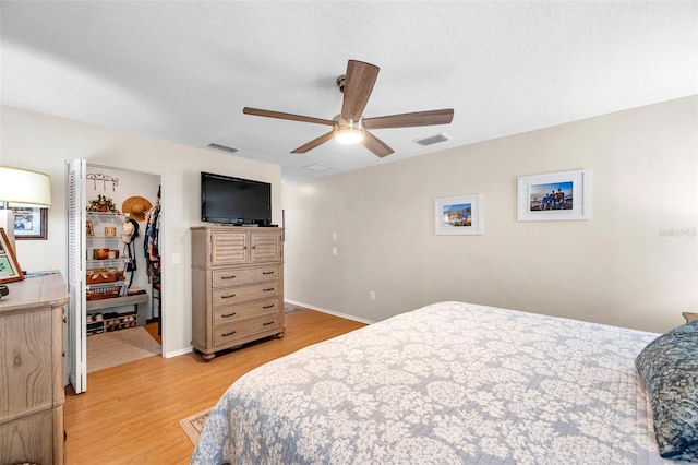 9335 Stonewall, New Port Richey, FL 34655 - bedroom with light wood-type flooring, a walk in closet, a closet, a ceiling fan, and baseboards