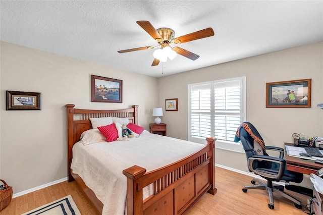 9335 Stonewall, New Port Richey, FL 34655 - bedroom featuring light wood-style flooring, an office area, baseboards, ceiling fan, and a textured ceiling
