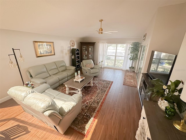 living room with wood finished floors, ceiling fan, and baseboards