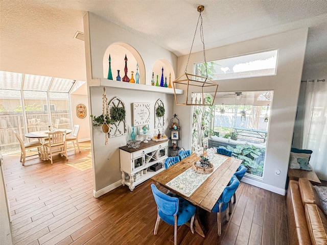 dining space featuring a textured ceiling, ceiling fan, wood finished floors, and baseboards