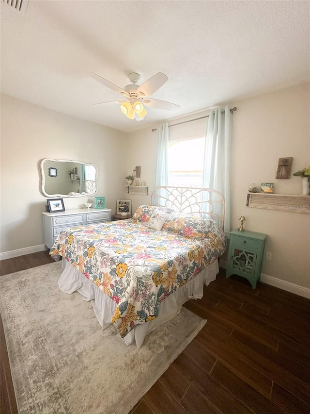 bedroom with wood finished floors, a ceiling fan, and baseboards