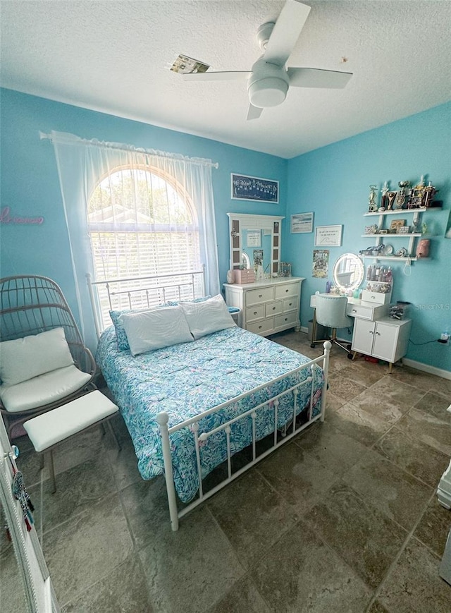 bedroom featuring a textured ceiling and a ceiling fan