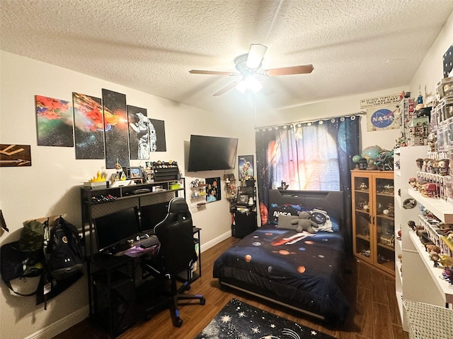 bedroom with a textured ceiling, ceiling fan, and wood finished floors