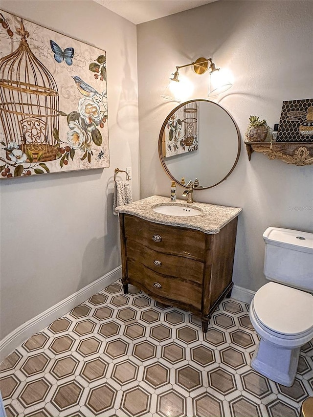 bathroom featuring vanity, toilet, and baseboards