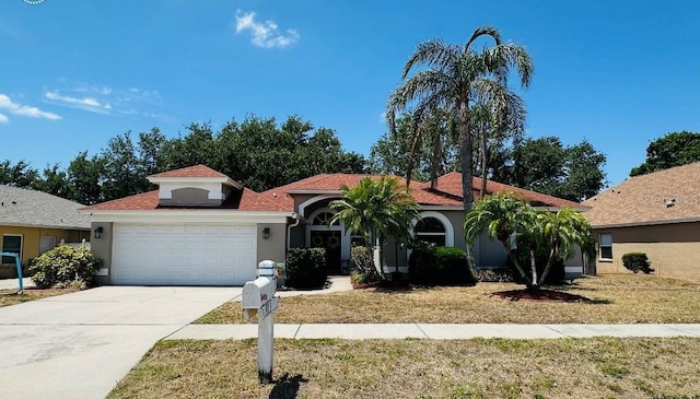mediterranean / spanish home with a front lawn, driveway, a garage, and stucco siding