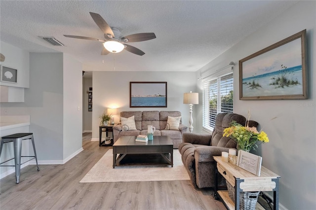 1349 New Bedford Dr Unit 6, Sun City Center, FL 33573 - living area featuring a textured ceiling, wood finished floors, ceiling fan, and baseboards