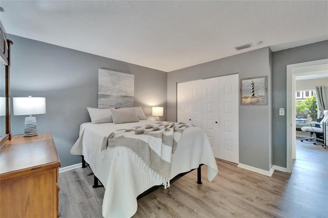 1349 New Bedford Dr Unit 6, Sun City Center, FL 33573 - bedroom featuring light wood-type flooring, a closet, baseboards, and a textured ceiling