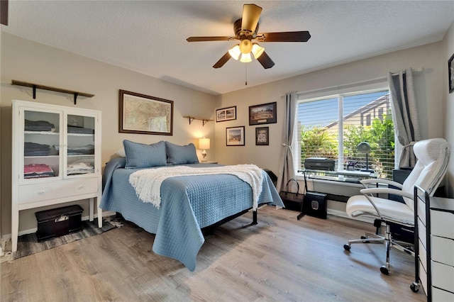 1349 New Bedford Dr Unit 6, Sun City Center, FL 33573 - bedroom featuring wood finished floors, an office area, a textured ceiling, and ceiling fan