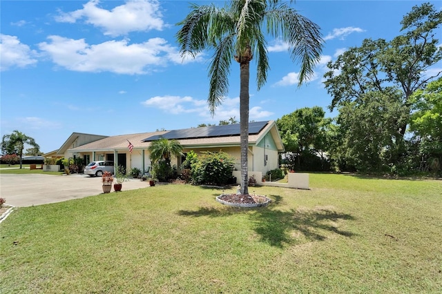 1349 New Bedford Dr Unit 6, Sun City Center, FL 33573 - ranch-style house with solar panels, a front yard, driveway, and stucco siding