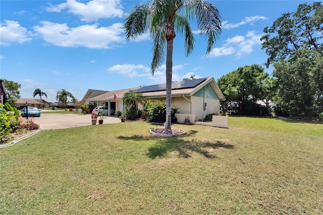 1349 New Bedford Dr Unit 6, Sun City Center, FL 33573 - view of front of property with solar panels, a front yard, stucco siding, and driveway