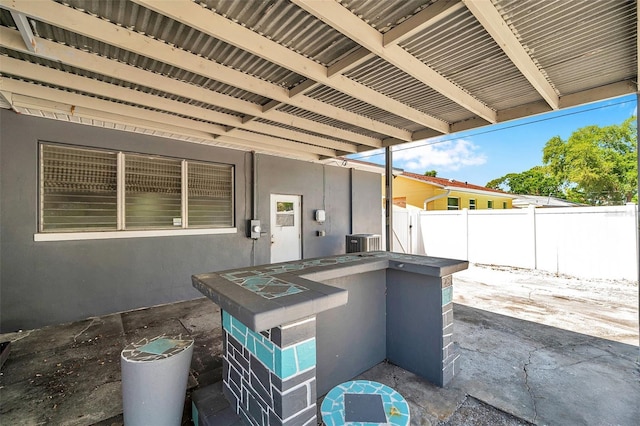 view of patio with a fenced backyard, outdoor dry bar, and cooling unit
