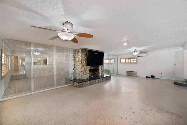 unfurnished living room featuring a ceiling fan, a textured ceiling, a wall mounted AC, and a stone fireplace