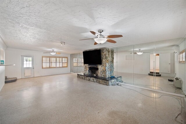unfurnished living room with a ceiling fan, a textured ceiling, a stone fireplace, and speckled floor