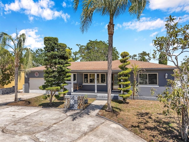 single story home featuring a porch, an attached garage, driveway, and stucco siding