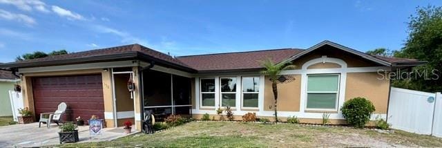 150 Tompkins St, Port Charlotte, FL 33954 - single story home with driveway, fence, a garage, stucco siding, and a sunroom