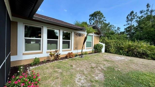 150 Tompkins St, Port Charlotte, FL 33954 - view of home's exterior featuring a yard and stucco siding