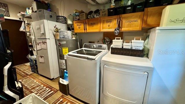 150 Tompkins St, Port Charlotte, FL 33954 - laundry room with water heater, cabinet space, and independent washer and dryer
