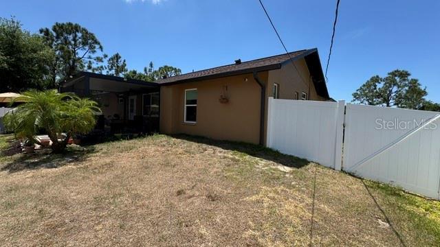 150 Tompkins St, Port Charlotte, FL 33954 - view of home's exterior featuring fence and stucco siding