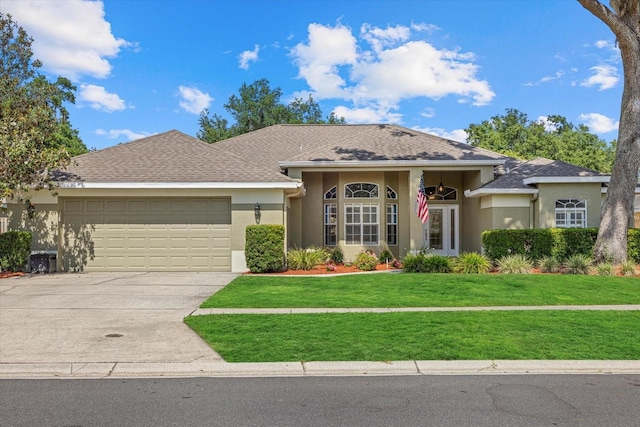 ranch-style house featuring stucco siding, an attached garage, driveway, and a front yard