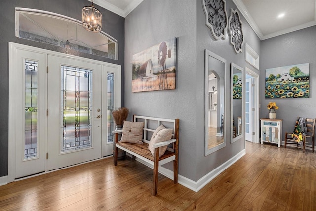 foyer entrance featuring crown molding, a textured wall, and wood finished floors