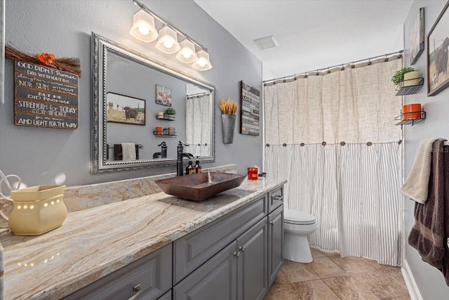 bathroom featuring toilet, visible vents, curtained shower, and vanity
