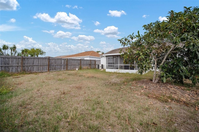view of yard with a sunroom and a fenced backyard
