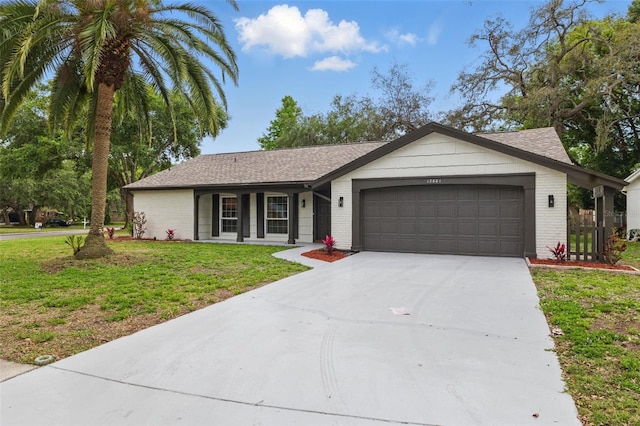 12601 Stone House Loop, Hudson, FL 34667 - ranch-style home featuring an attached garage, concrete driveway, brick siding, and a front yard
