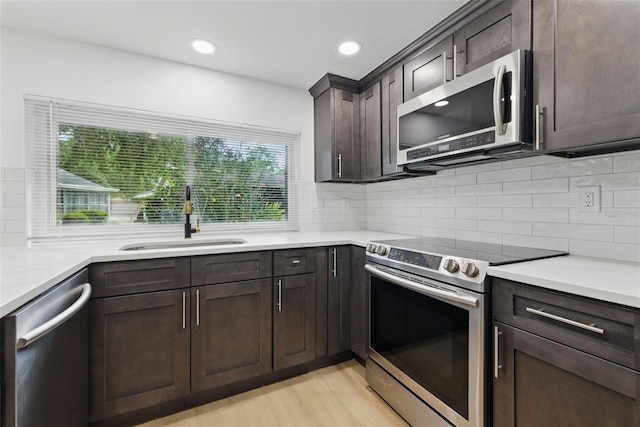 12601 Stone House Loop, Hudson, FL 34667 - kitchen with a sink, decorative backsplash, appliances with stainless steel finishes, and dark brown cabinets