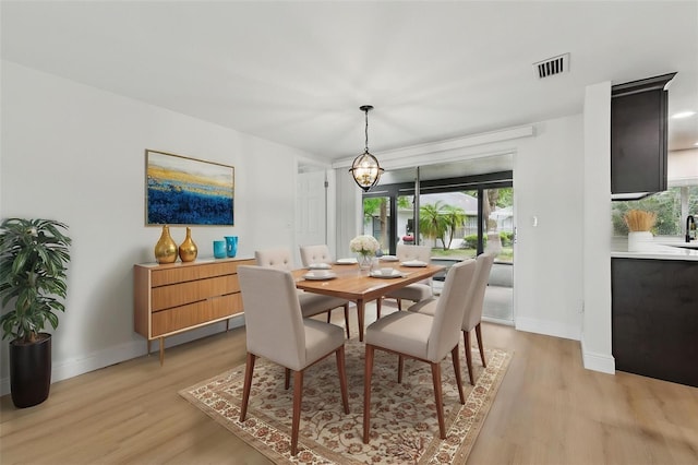 12601 Stone House Loop, Hudson, FL 34667 - dining space featuring light wood-style floors, baseboards, visible vents, and an inviting chandelier