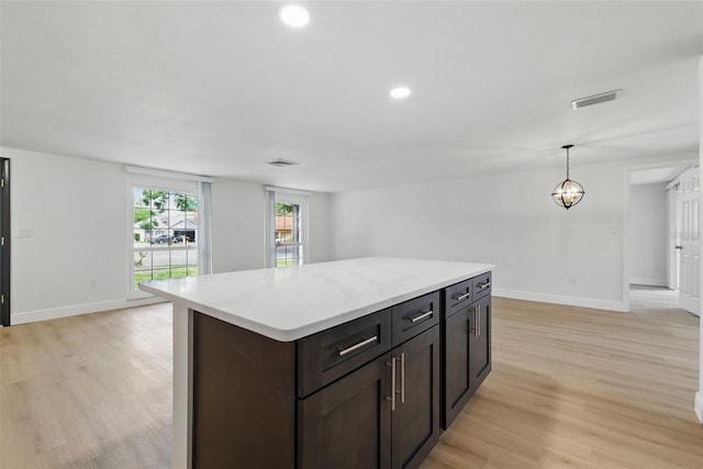 12601 Stone House Loop, Hudson, FL 34667 - kitchen with baseboards, a center island, visible vents, and light wood-style floors
