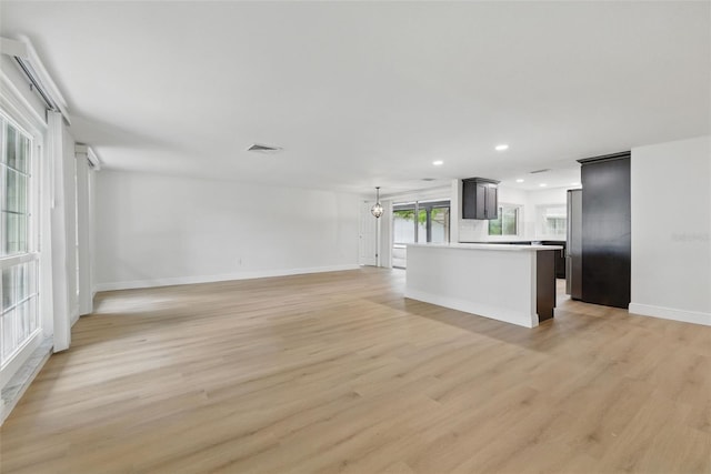 12601 Stone House Loop, Hudson, FL 34667 - unfurnished living room with recessed lighting, baseboards, light wood finished floors, and visible vents