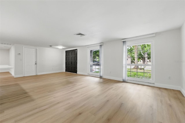 12601 Stone House Loop, Hudson, FL 34667 - unfurnished living room with a healthy amount of sunlight, light wood-style floors, and visible vents