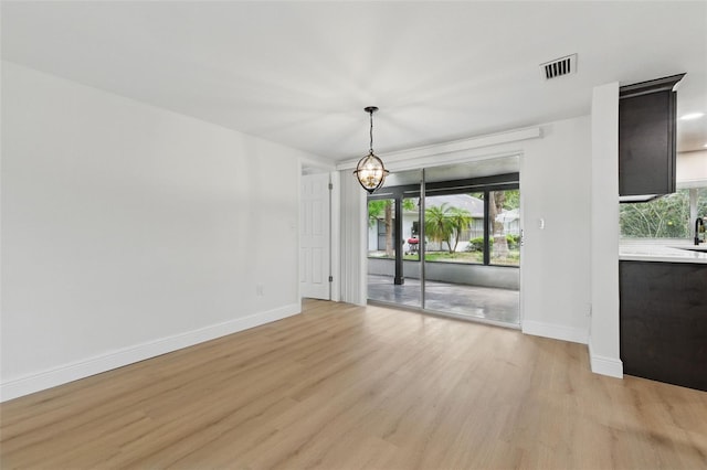 12601 Stone House Loop, Hudson, FL 34667 - interior space with light wood-type flooring, baseboards, a chandelier, and visible vents