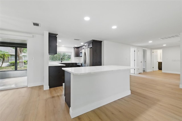 12601 Stone House Loop, Hudson, FL 34667 - kitchen featuring baseboards, visible vents, stainless steel fridge, and light wood-style flooring