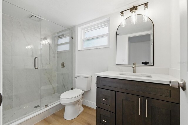 12601 Stone House Loop, Hudson, FL 34667 - full bathroom featuring vanity, a stall shower, toilet, and wood finished floors