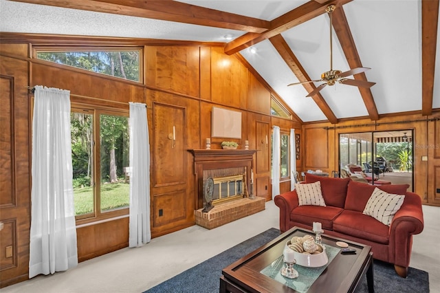 carpeted living area featuring wooden walls, plenty of natural light, and a fireplace