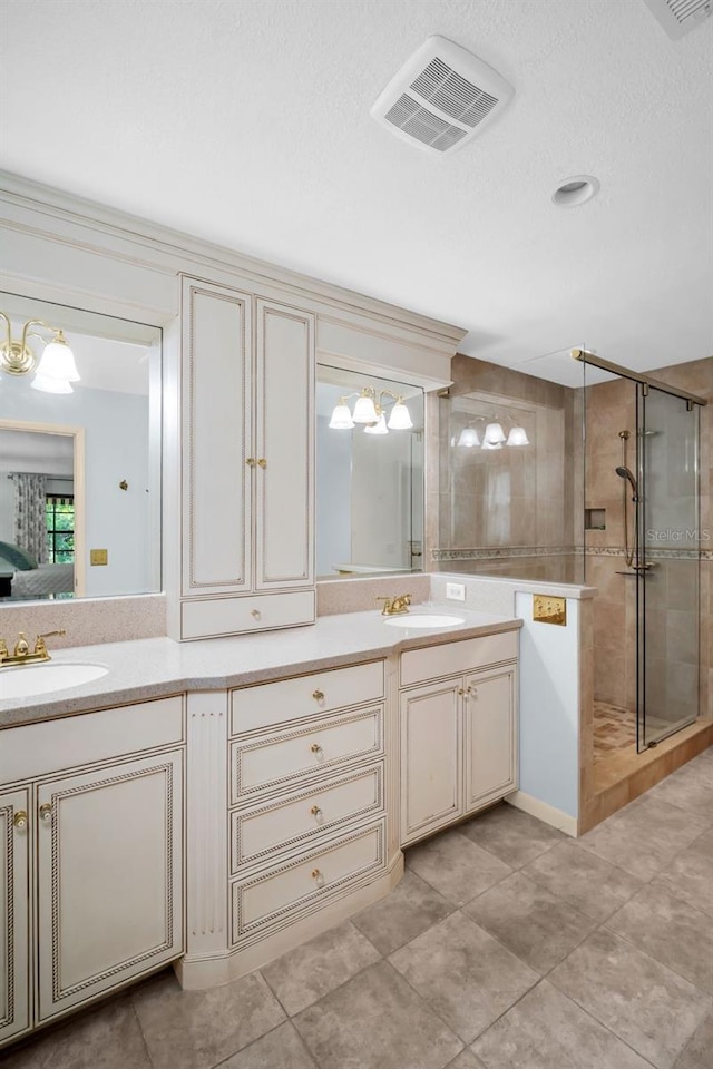 full bathroom with a sink, a stall shower, double vanity, and visible vents