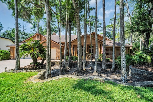 10 Greenhaven Cir, Oldsmar, FL 34677 - view of front of property featuring a garage, decorative driveway, a front lawn, and a chimney