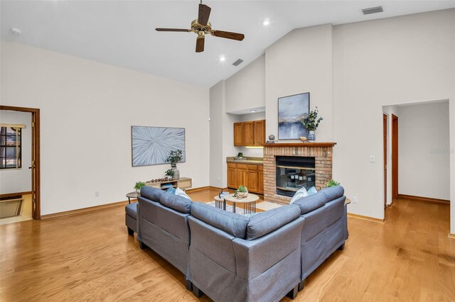 10 Greenhaven Cir, Oldsmar, FL 34677 - living room featuring high vaulted ceiling, ceiling fan, light wood-type flooring, baseboards, and a fireplace